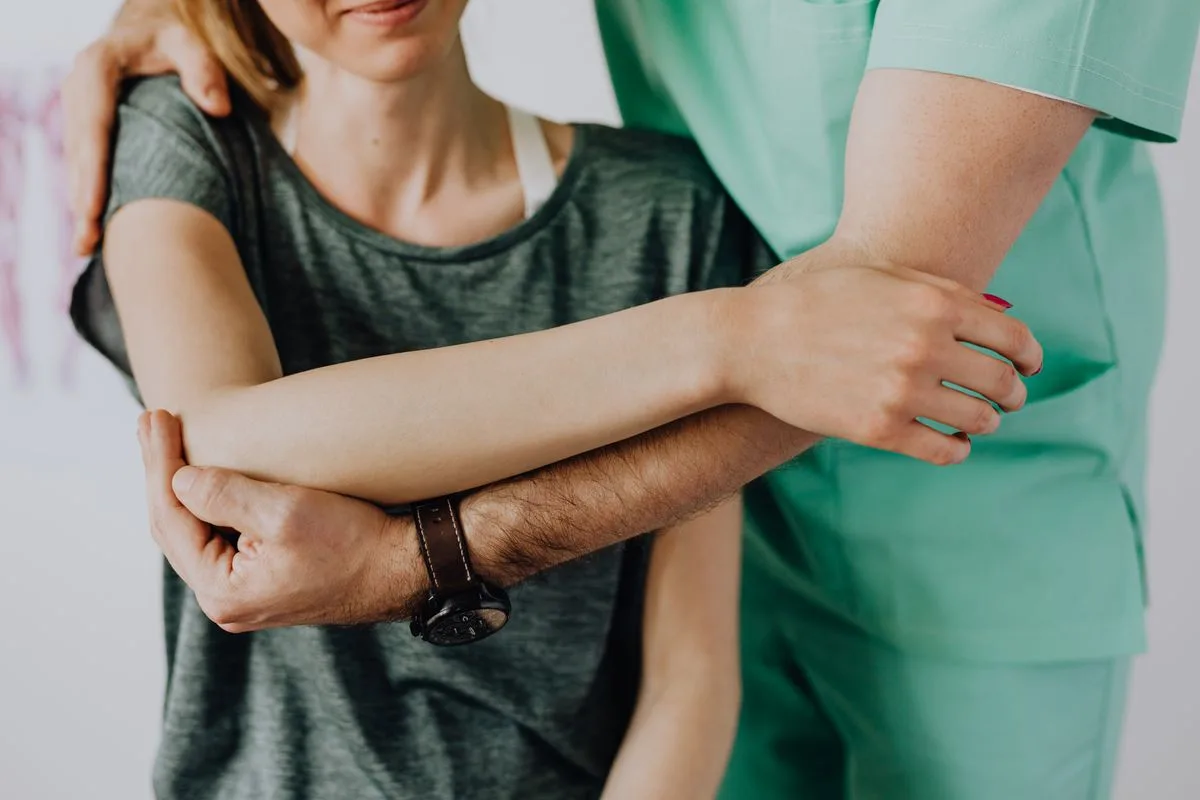 Therapist assessing a patient's rotator cuff and shoulder strength