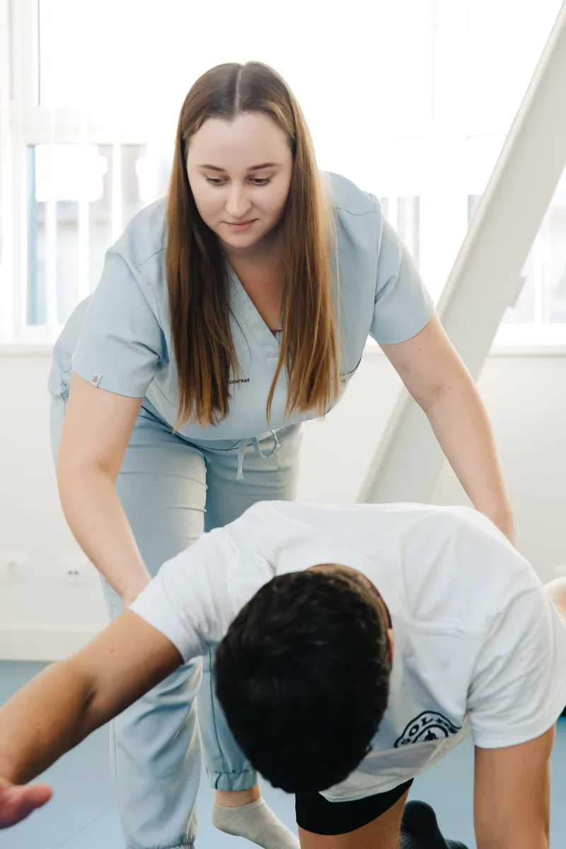 Physical therapist guiding a patient through a balance and strength exercise